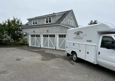 white trim garage doors with Rob Gagne's overhead repair truck pulled up